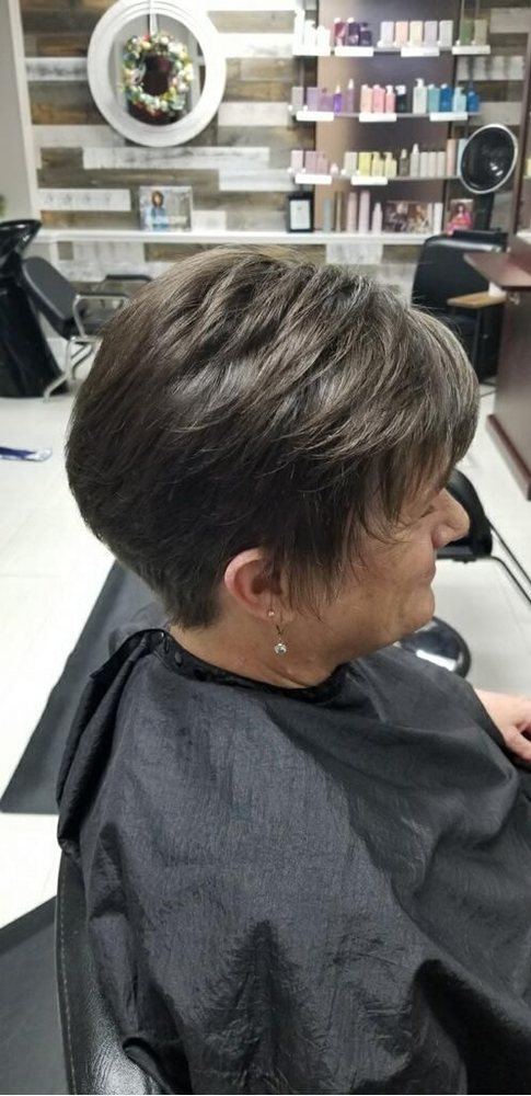 Side view of a short, tapered brunette cut on a client in the salon chair