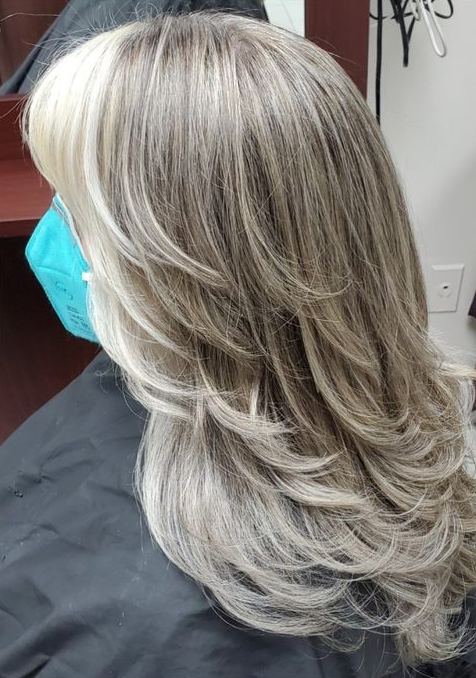 Long layered hair in soft silver and ash tones with bright face-framing pieces